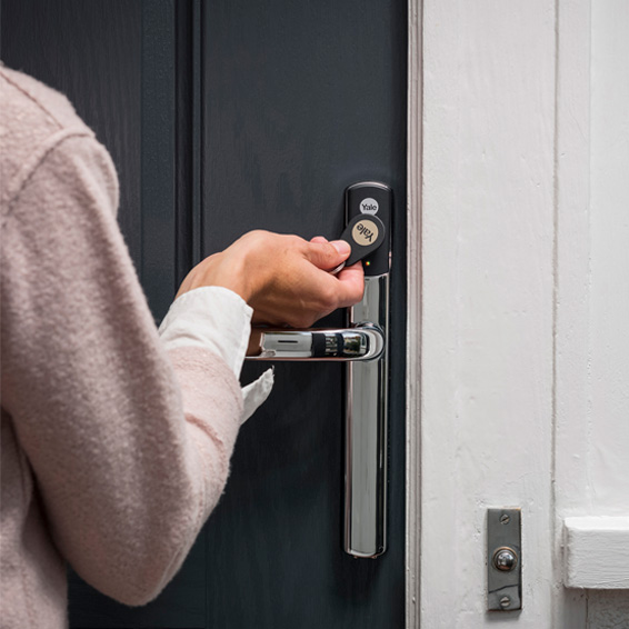 Woman opening her Door using the Conexis&reg; L2 Smart Door Lock and key tag