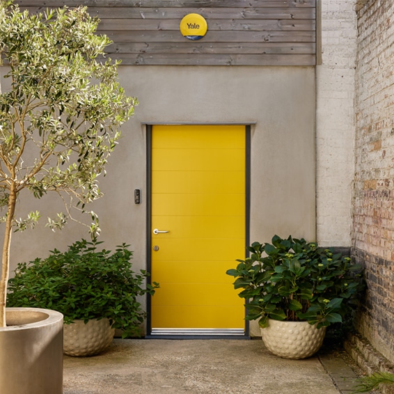 Front of a house, showing the Yale Smart Video Doorbell and the Yale Smart Alarm Siren